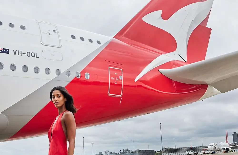 Karryon Top 10 stories of the week: Catch up on our most-wanted: Oct 3 9 Model in red dress on airport tarmac with Qantas plane tail in background to illustrate Qantas Frequent Flyer promotion.