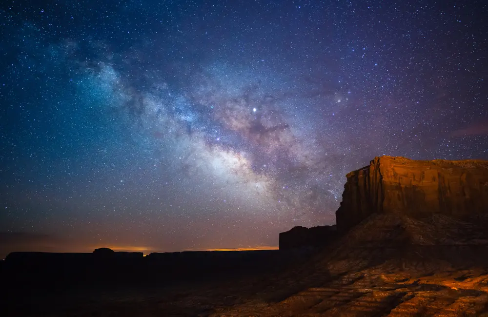 Visit Utah shares 2025 highlight reel with new movie markers & local indigenous tourism 3 Milky Way galaxy of stars as seen above arch in Monument Valley, Utah.