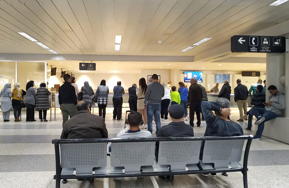 Seated and standing passengers waiting at Beirut airport.