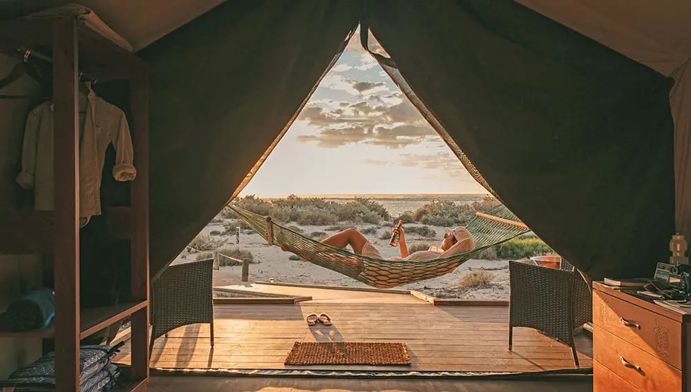 Person holding beer outside tent at Sal Salis Ningaloo Reef, Journey Beyond.