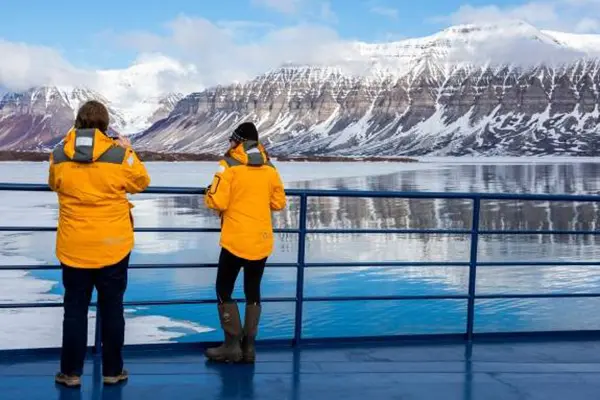 Two people on a Quark Expeditions ship looking at ice landscape in Spitzbergen, Norway.