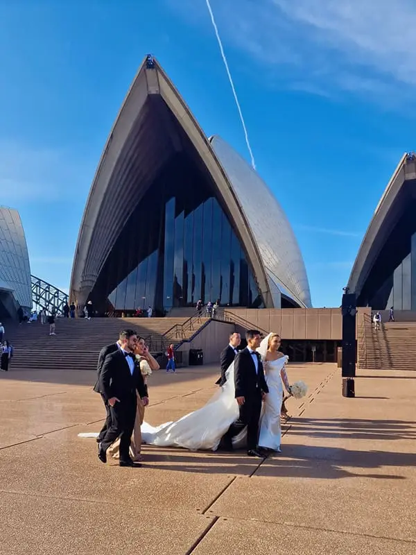 The surprising global destination wedding locations for loved-up couples to tie the knot 5 Wedding party taking photos in front of Sydney Opera House.