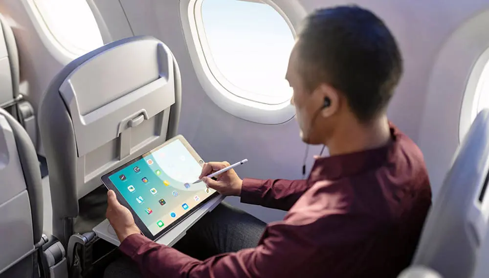 Embraer the first to launch automatic takeoff for commercial jets; reveals enhanced cabins 2 Passenger using tablet in seat on Embraer E-Jet E2 aircraft.