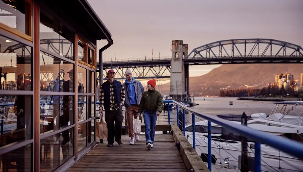 Three men walking on jetty at Granville Island, Vancouver. Viva Holidays