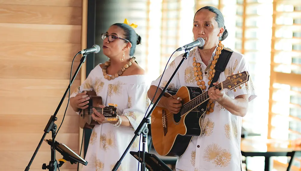 Two musicians perform traditional Hawaiian music at Aloha Down Under 2024 event.