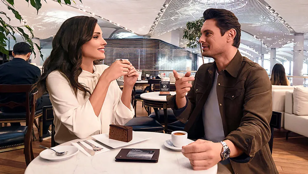 Man and woman drinking coffee at Turkish Airlines International Lounge beverage area at Istanbul Airport.