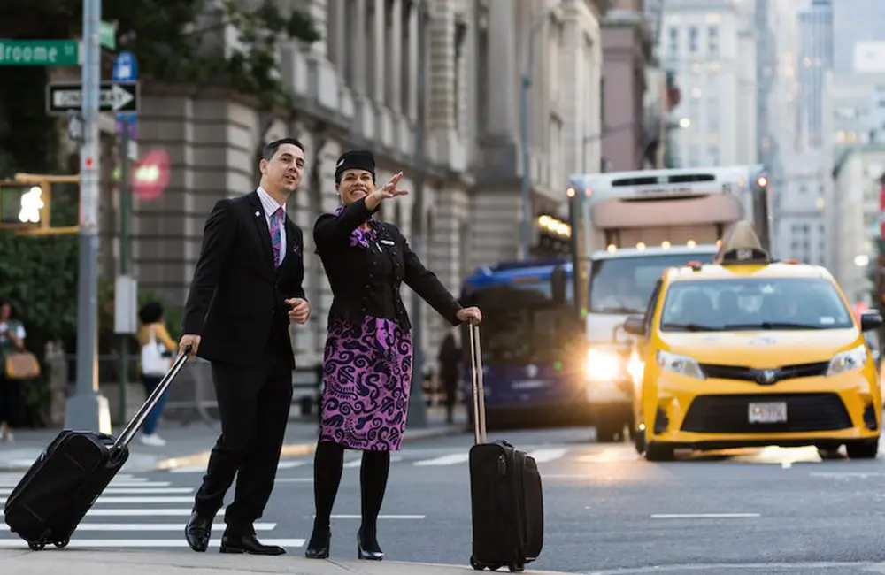 Hot dog! Helloworld agent snaps up NYC trip in Air New Zealand x Viva Holidays incentive 2 Air New Zealand crew members with luggage in busy Manhattan street in NYC