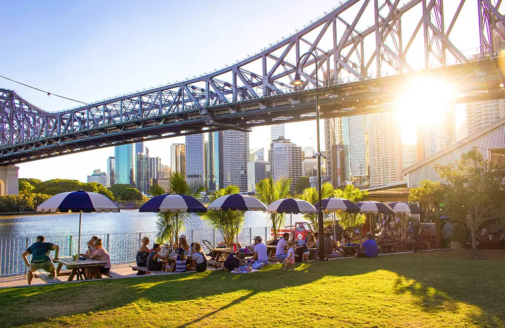 Outdoors on the lawn at Howard Smith Wharves on the Brisbane River with Story Bridge.