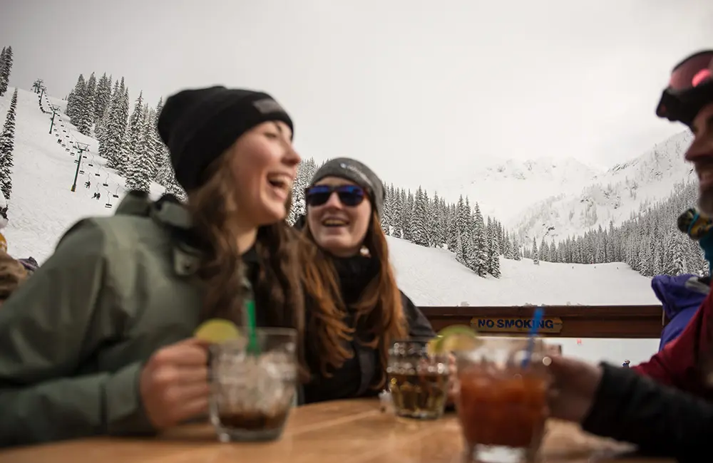 Is this destination even hotter than Japan among Aussie snow holidaymakers? 2 Group having apres-ski drinks outdoors at Whitewater Ski Resort, BC, Canada