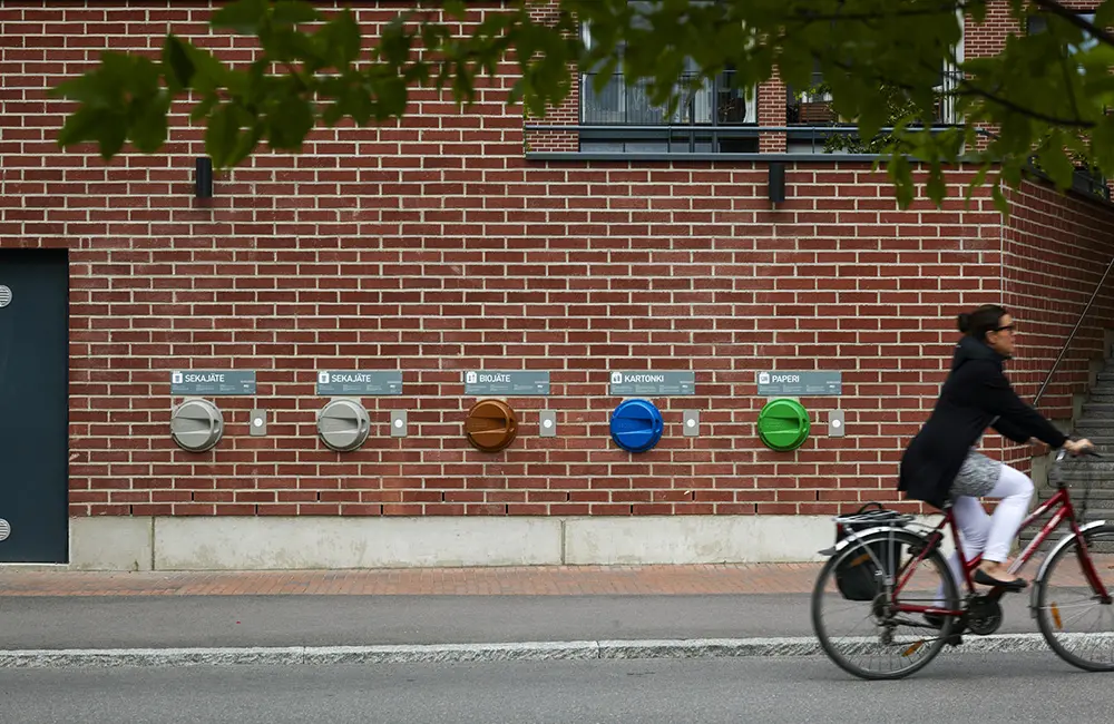 This European city is now the world’s most sustainable travel destination 2 A woman bikes past recycling bins in Kalasatama as Helsinki is named the world's most sustainable travel destination. Image: City of Helsinki/Riku Pihlanto