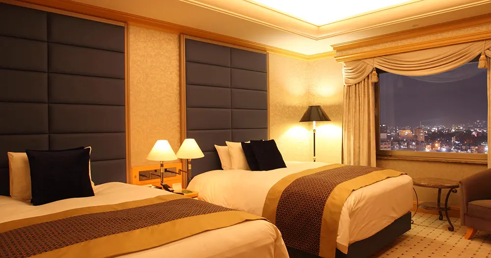 Make a Japan train holiday rail-ly easy for your clients with JR-East Hotels 6 Imperial Suite Room with night view at Hotel Metropolitan Nagano in Japan.