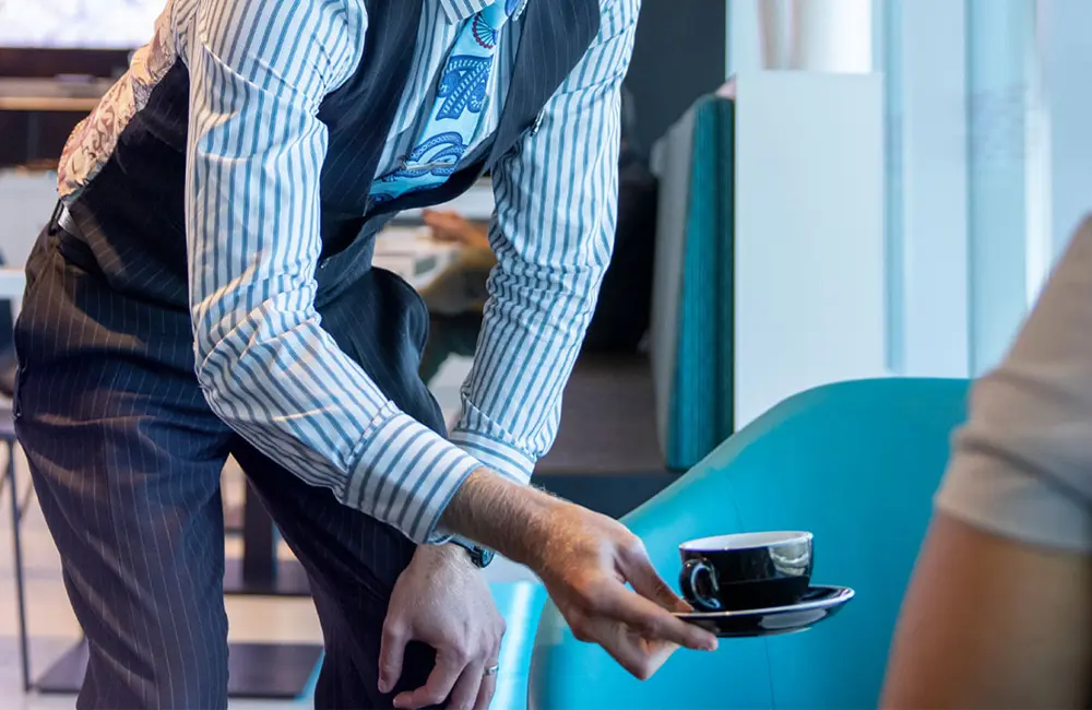 'Greenwishing' & how travel companies can avoid this issue to reach net zero by 2050 6 Passenger receives coffee at New Plymouth Airport Air New Zealand Lounge