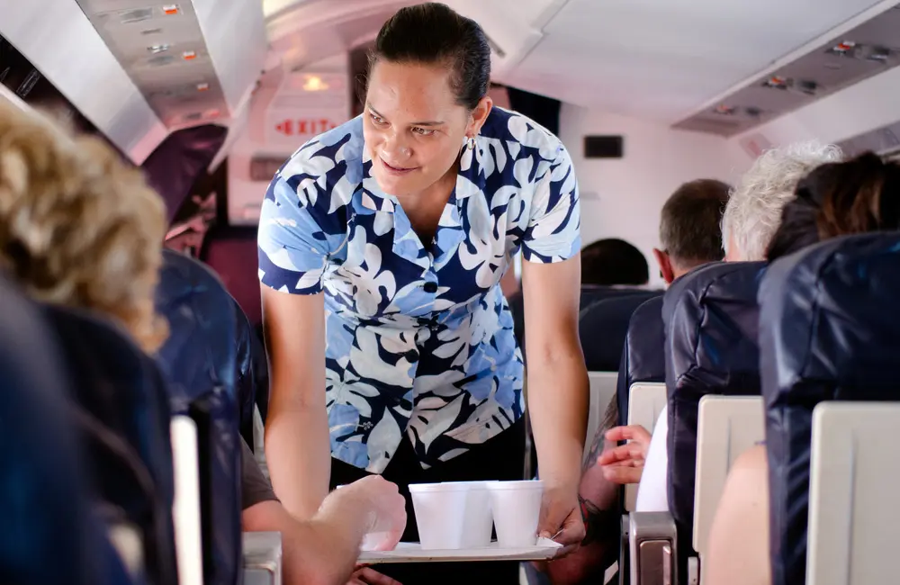 Flight attendant during Air Rarotonga inflight service. Image: ChameleonsEye/Shutterstock