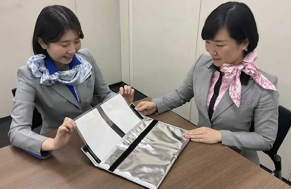 Say sayonara to seasonal: ANA makes Perth-Tokyo a permanent fixture 2 ANA cabin crew take a closer look at the storage bag for electronic devices.