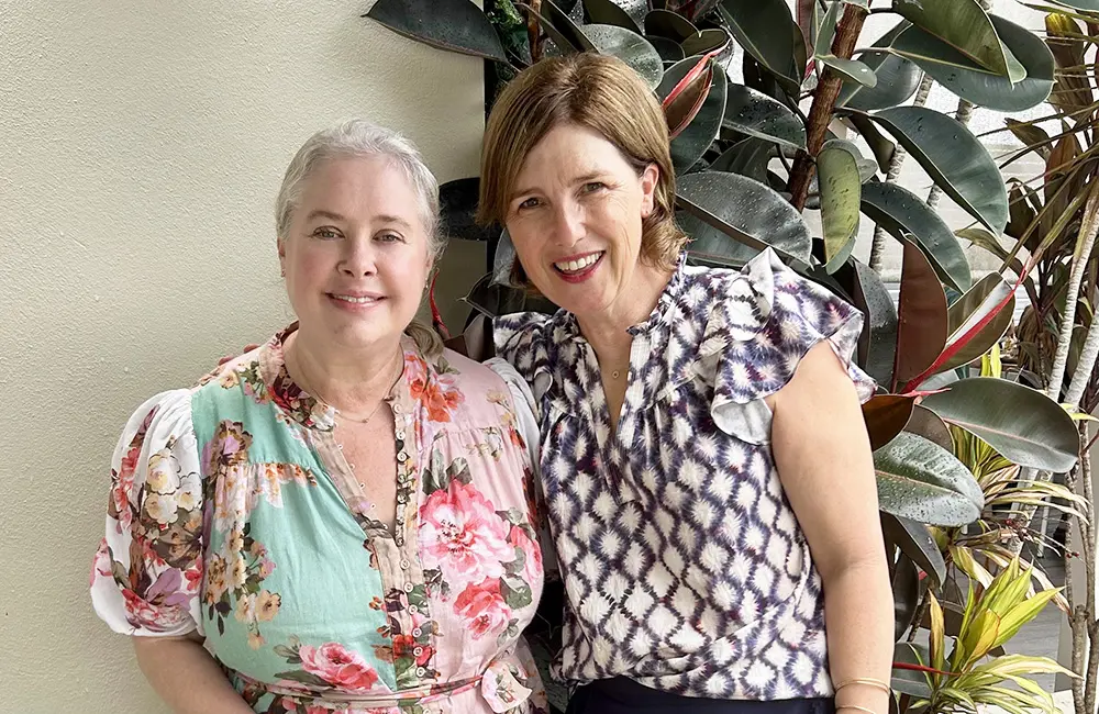Are you ready to level up your travel business with itravel? 4 Travel With Adela owner Adela Backhouse with itravel National BDM Jo Howard pose with plant.