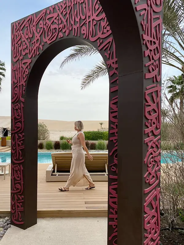 Qatar Airways and Visit Qatar Mega Famil wows 80 Aussie travel professionals in Doha 6 Woman walking past arched entrance with pool at The Outpost Al Barari in Qatar. Image: Cassie Tannenberg