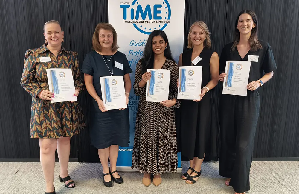 Five women pose with graduation certificates against TIME branded backdrop in Sydney office.