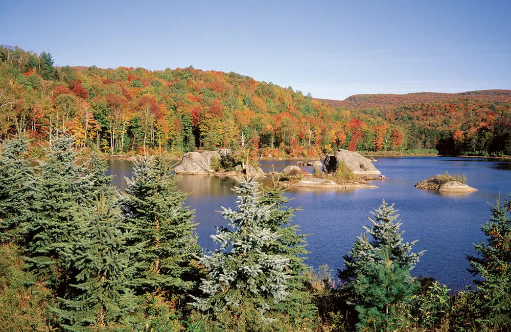 Québec in autumn and winter: Quintessential appeal in stylish cities, wintry festivities & Indigenous immersion 2 Lake and autumn landscape in Eastern Townships, Quebec.