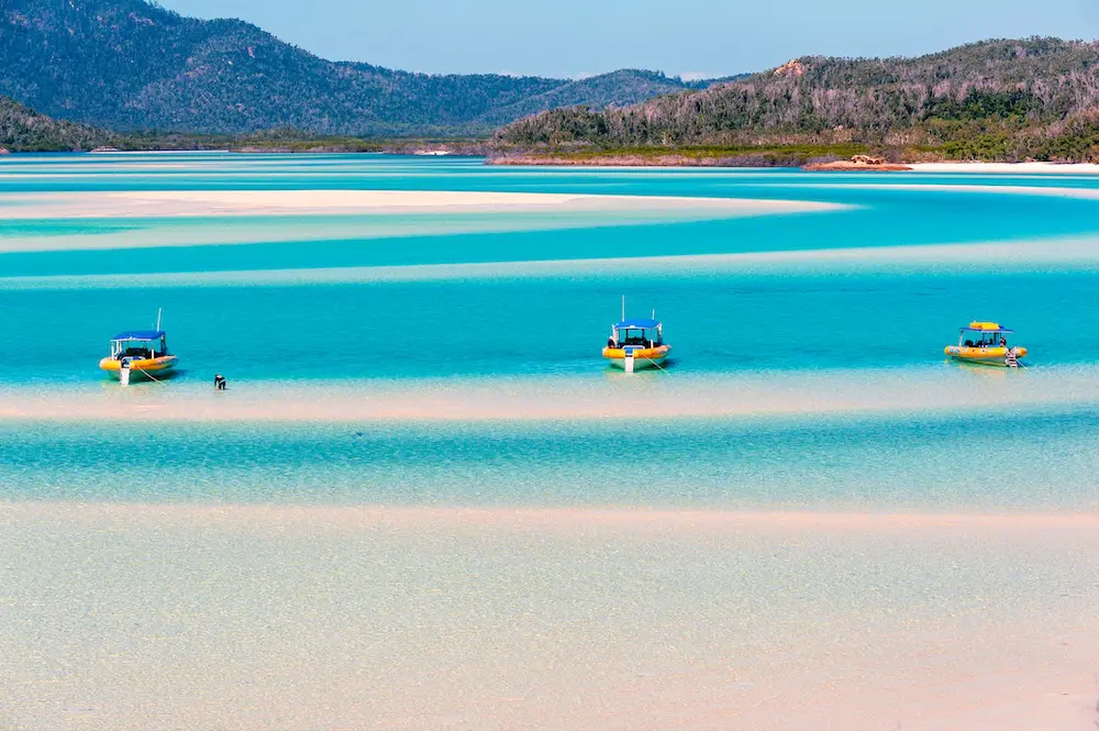 Record growth in travel and tourism businesses - but do survival rates tell a different story? 2 Hill Inlet, Whitsunday Island, Queensland, Australia - Jul 23, 2018: Inflatable yellow dive boats moored on the sandbanks in clear blue water at Hill Inlet under a clear sky. Patterns in the white sand.