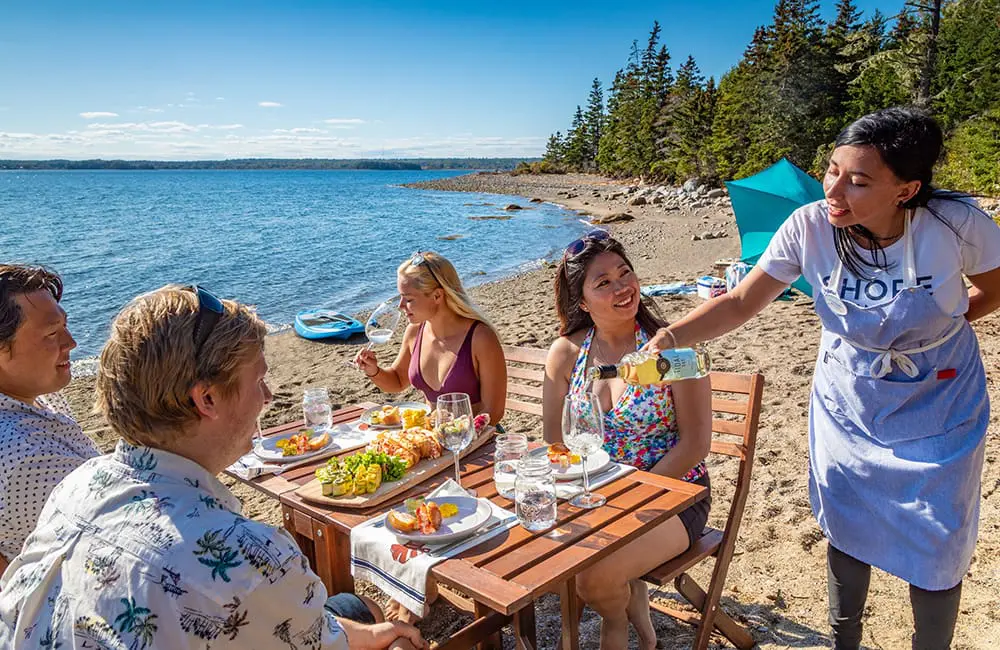 Atlantic Canada in autumn: 4 East Coast provinces with diverse cultures, sea-to-table flavours & alluring nature 7 Group dining on a beach in Nova Scotia. Image: Tourism Nova Scotia/Acorn Art & Photography