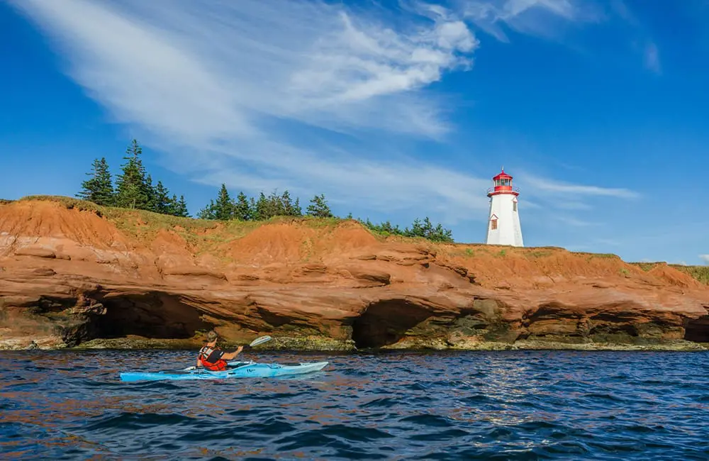 Atlantic Canada in autumn: 4 East Coast provinces with diverse cultures, sea-to-table flavours & alluring nature 14 Man kayaking near Seacow Head Lighthouse on Prince Edward Island. Image: Sean Landsman