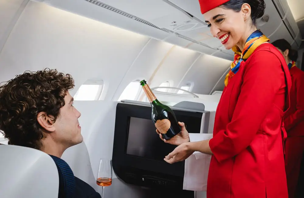New long-haul UK airline operates first transatlantic flight from Scotland to NYC – without a licence 1 Global Airlines crew serves champagne to passenger – UK airline