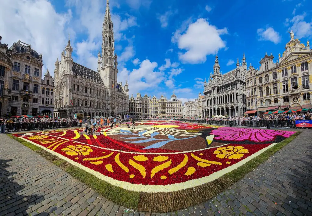 DFAT gives new travel advice level for popular western European nation 2 Brussels flower carpet panorama of Grand Place with people arranging last dahlia flowers, Brussels, Belgium.
travel advice