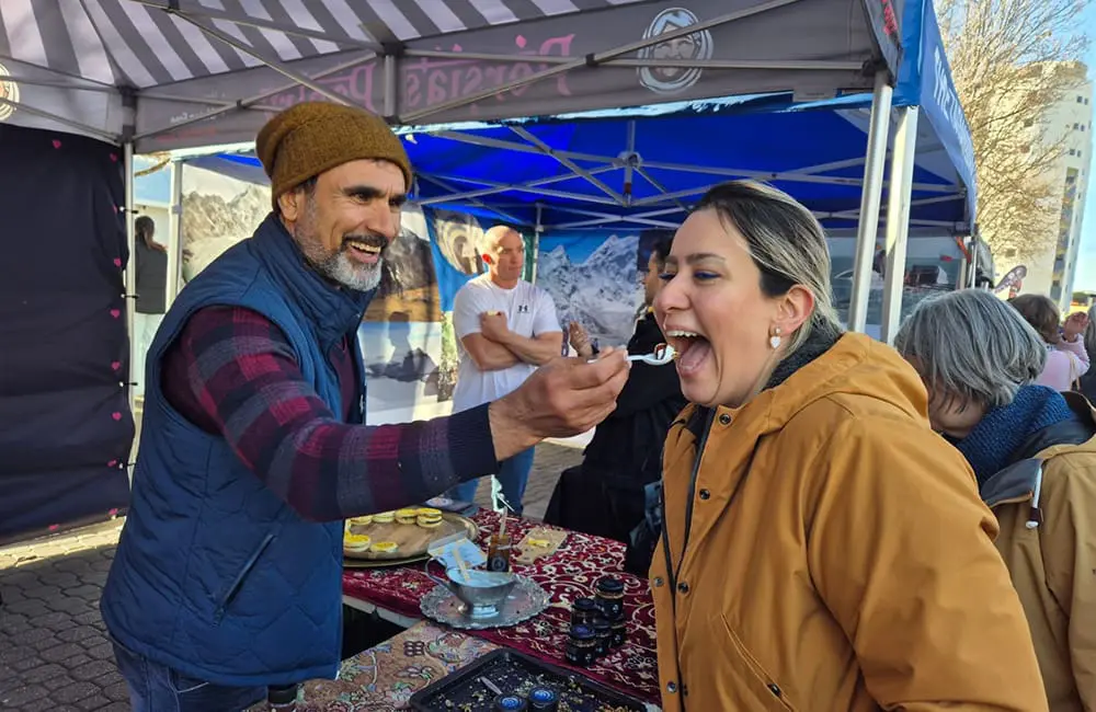 Connection & celebration: Connected Travel stages first-ever national conference in Hobart 5 Travel agent trying a sample at outdoors market in Hobart.