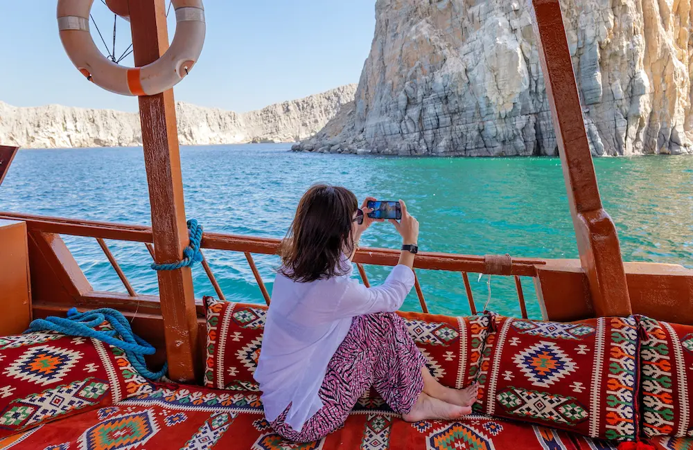 Bill blowouts: 4 in 5 Aussies fear sky-high roaming charges after travelling abroad 3 a tourist dhow boat, takes photos of cliffs and fjords by phone, Khasab, Musandam, Oman