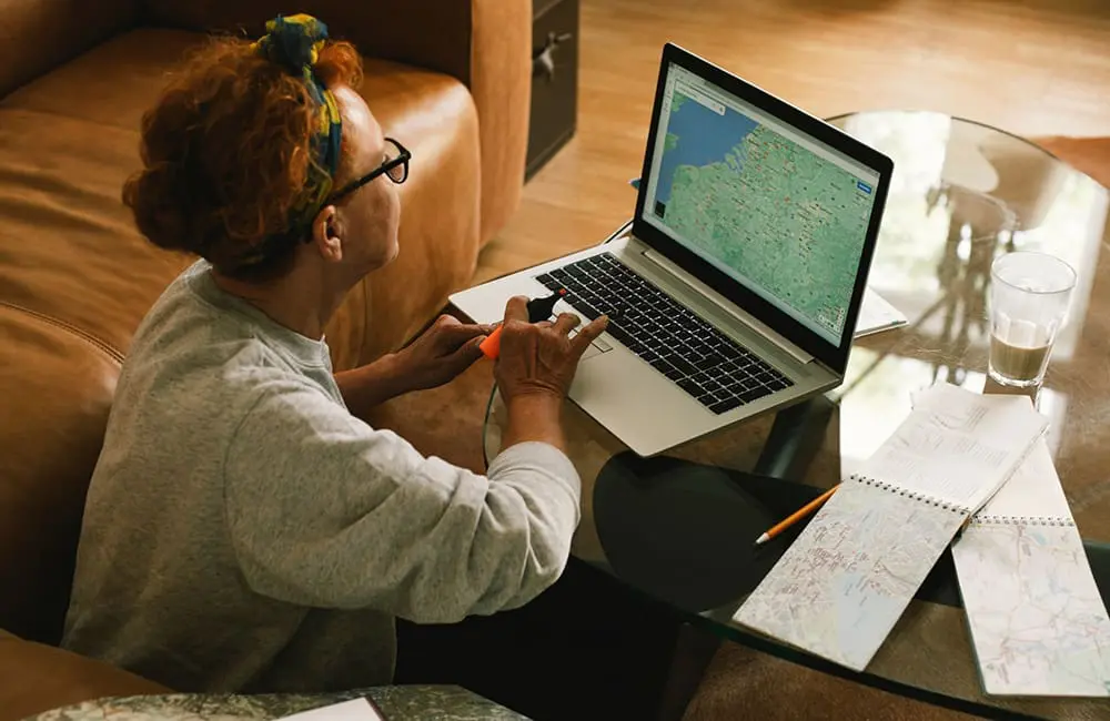 Expedia TAAP rolls out smarter payment options to boost agent revenue & efficiency 2 Female travel advisor sitting on floor with laptop and maps working from home – Expedia TAAP
