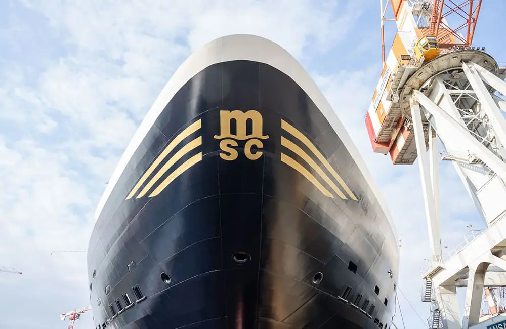 Explora Journeys makes waves with 3 major ship milestones in one day 1 Close-up of EXPLORA III ocean cruise ship hull at shipyard during float-out ceremony.