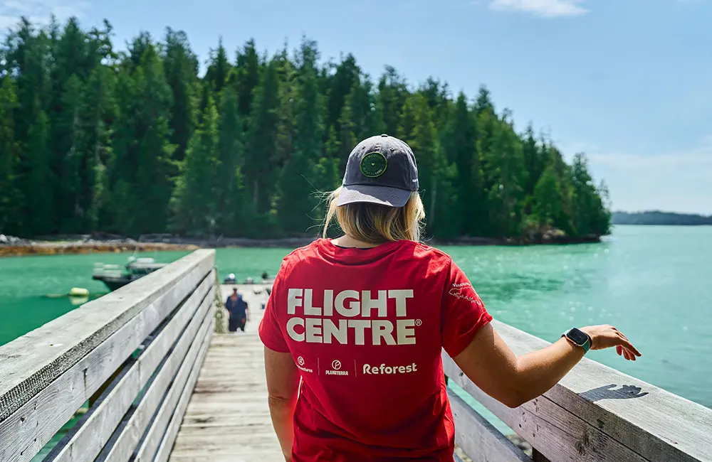 Flight Centre to launch new leisure loyalty program in 2025 as it reveals record transactions 2 Female with back to camera with red Flight Centre Reforest t-shirt on Vancouver Island.