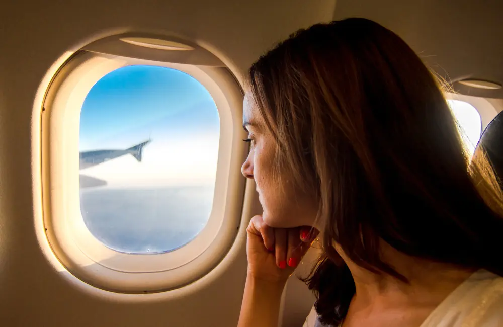 Karryon Top 10 stories of the week: Catch up on our most-wanted: Aug 1 9 Female plane passenger looking out of window at sunrise.