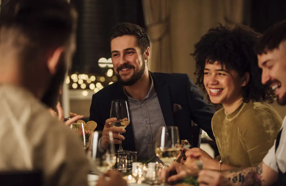 Aussies prioritise plush stays over planes: Luxury hotels win for travel spend 2 Groups of friends enjoying fine dining at table – travel spend trends