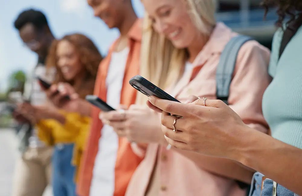 Australia ranks 14th globally for traveller-friendly internet but best in region 4 Tight shot of row of Gen Z travellers outdoors with smartphones using AI