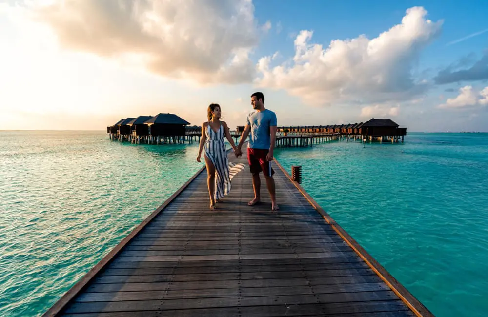 Aussies prioritise plush stays over planes: Luxury hotels win for travel spend 1 Couple at overwater bungalows at luxury resort in Maldives – travel spend trends