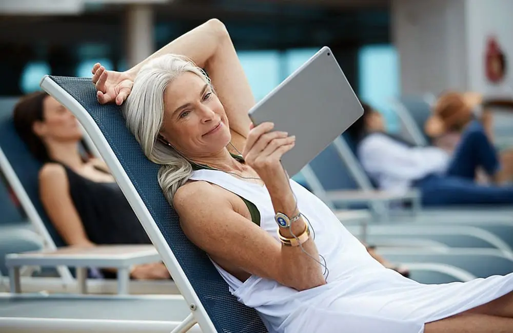 More extras, more credit: Princess pumps up the value on Premier & Plus packages 1 Women on deckchair on Princess Cruises ship using Wi-Fi and device for Princess Premier and Plus packages
