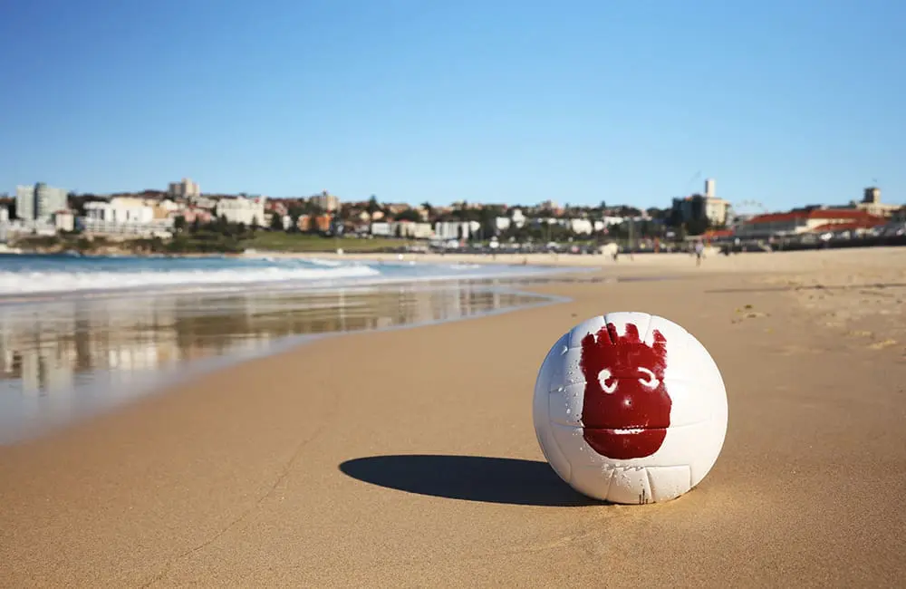 Tourism Fiji’s new campaign has a familiar face with 3 free trips to Fiji up for grabs 2 Wilson volleyball with red face handprint on an Australian beach for Tourism Fiji campaign