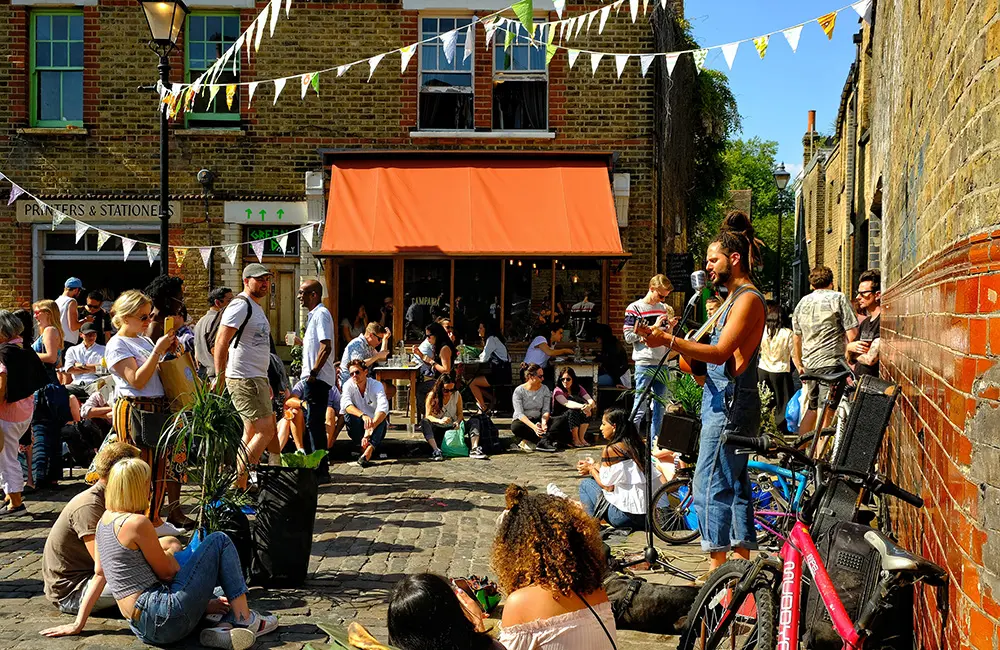 The unexpected destinations topping Emirates’ 2025 summer holiday list 3 People listening to musician in Hackney, East London on a sunny day