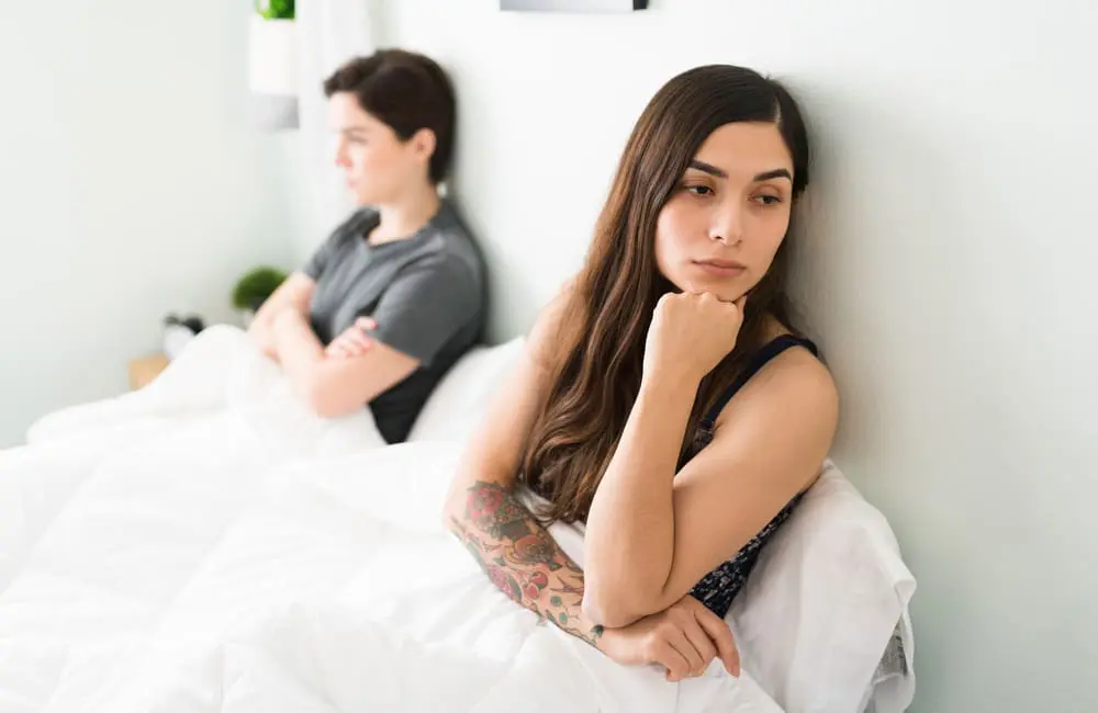 Romance vs reality: Holidays spark clashes for 40% of Aussie couples 2 Lesbian couple in bed facing away from each other – arguments on holidays. Image: Shutterstock