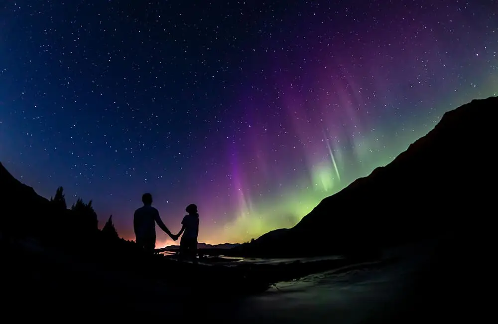 Silhouette of couple against Northern Lights in fall from Anchorage. Image: Ralph Kristopher Photos