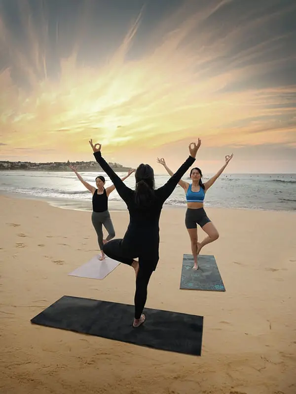 More Zen, less stress? Wellness wave ushers new 'era of enrichment' for Aussie tourism 1 intructor and two women at Private Yoga Bondi Yoga by the Sea for wellness tourism concept. Image: Big Red Group