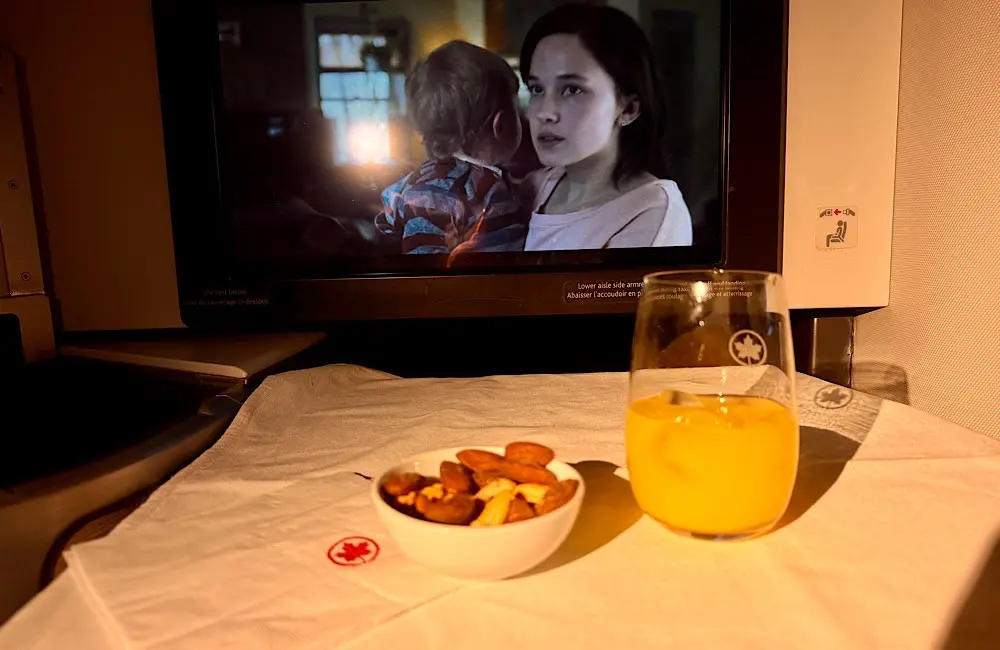 Signature Class Flight Review: Air Canada AC33 Vancouver to Sydney and the long‑haul dilemma of sleep or story 1 A glimpse of inflight dining and entertainment: a quiet moment with fresh juice, warm nuts, and one of over 1,000 films in Air Canada’s IFE library.