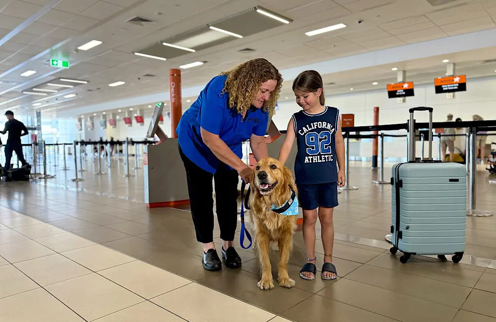 Meet Ace, Cairns Airport’s furriest new recruit 1 Ace and Linda with a young traveller, showcasing Cairns Airport’s focus on accessibility and passenger care.