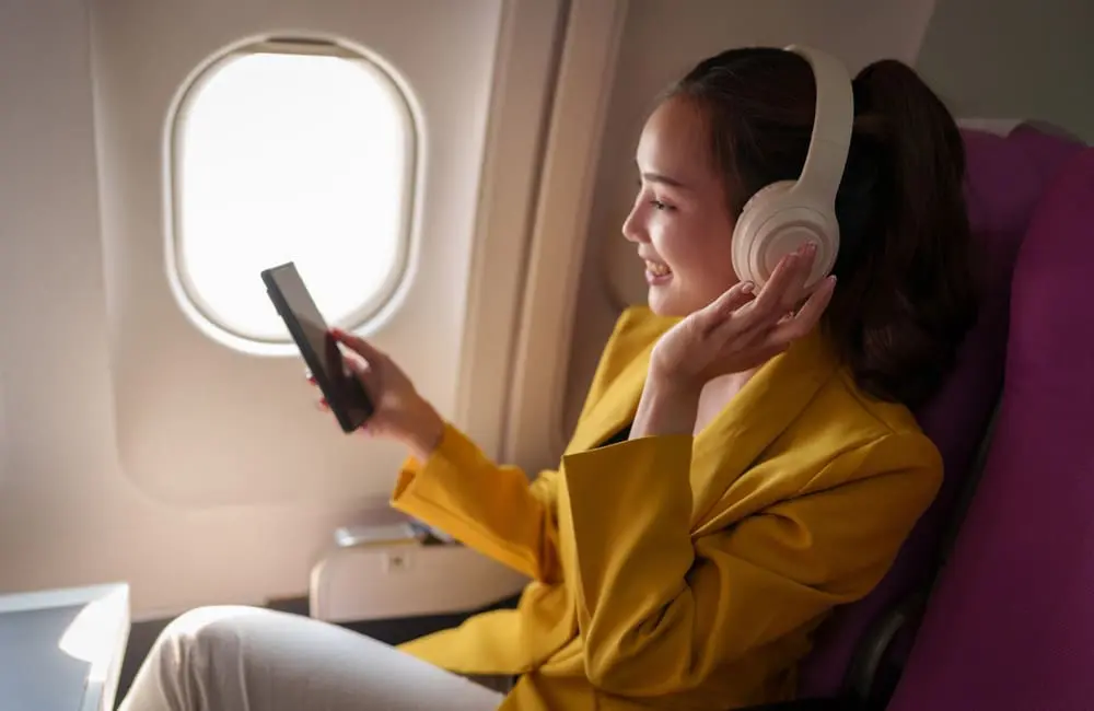 Wi-Fi withdrawal? 1 in 5 Aussies can’t travel without being connected 1 Female plane passenger with headphones and mobile phone for inflight Wi-Fi connectivity