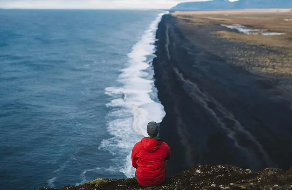 Tauck launches new luxury brand – its first in a decade – and it’s geared for a specific demographic 2 Man sitting on cliff edge looking at sea – Roam by Tauck