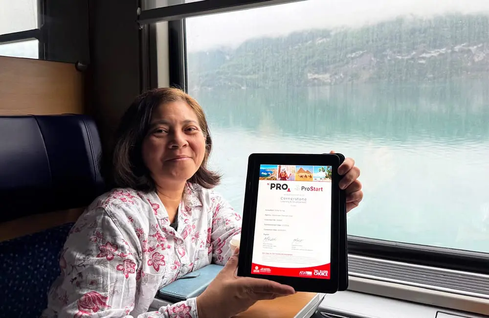 TC ProStart graduate Emilie Yu-Yap from Global Travel Co holds tablet with certificate on ship.