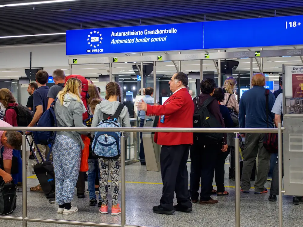 New way to enter and exit Europe starts on Sunday for Australian travellers 1 June 18, 2017. An airport employee waves citizens of the European Union through to the automated border control gates. Frankfurt Airport, Germany. Immigration and travel editorial concept.