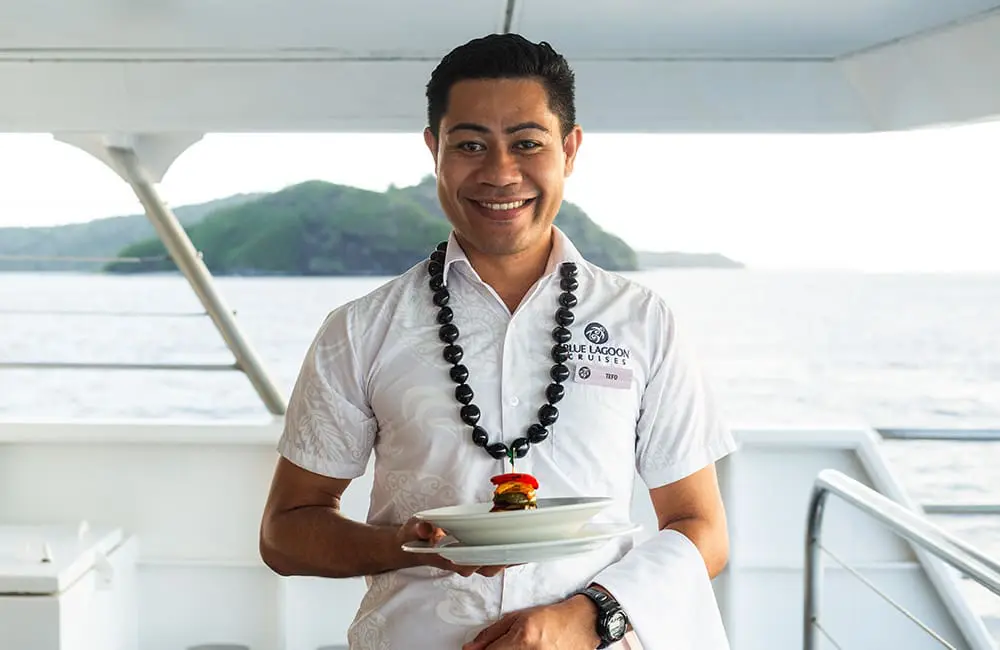 Making waves in Fiji: Blue Lagoon Cruises crowns small-ship fleet with a second Princess in 2026 2 Blue Lagoon Cruises staff member Tefo serving dinner on board ship.
