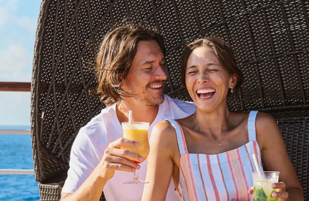 Couple on a Carnival Cruise Line ship at sea enjoying alcohol-free drinks.
